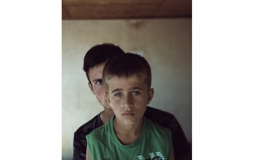 fot. Radosław Polak,
„Father’s Guil(t)” (Projekt liczy 18 zdjęć), 1. miejsce w kategorii Projekty Dokumentalne. Mężczyźni, których spotkałem w gruzińskiej Dolinie Pankisi, nie mówią wiele o uczuciach. Większość z nich to doświadczeni wojną byli mudżahedini – święci wojownicy, którzy aby walczyć, zostawiali swoje rodziny, w tym synów, na długie miesiące albo i lata. Z czasem zacząłem odczuwać coraz więcej emocjonalnych podobieństw pomiędzy mną a nimi. W historiach spotykanych tam mężczyzn widziałem przeróżne warianty swojej relacji z ojcem. Wracałem, by znów dotknąć tłumionych przez lata uczuć: rozłąki, lęku, złości, nienawiści, tęsknoty. A w końcu: wybaczenia, miłości, chęci naśladowania, posłuszeństwa i szacunku. Na kolejne wyprawy do Pankisi odważyłem się zaprosić ojca i pojechaliśmy już razem, dołączył też do nas mój brat ze swoim dorastającym synem.

Dzięki mężczyznom z Doliny Pankisi odnalazłem drogę do pojednania się z moim ojcem. Drogę do własnej męskości. Drogę do domu.