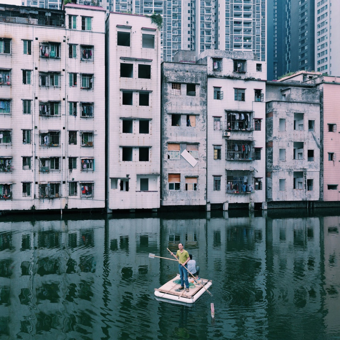 fot. Yuyang Liu / Decade of Change<br></br><br></br>
Guangzhou, Chiny, 2015. Dwóch mężczyzn łowi ryby w stawie Xian Village, który znajduje się w centrum miasta Guangzhou. Przez ponad 7 lat istniał konflikt między lokalnymi mieszkańcami a deweloperami z powodu nierównych wynagrodzeń i korupcji przywódców wiosek Xian. Wioska Xian jest uosobieniem urbanizacji Chin.